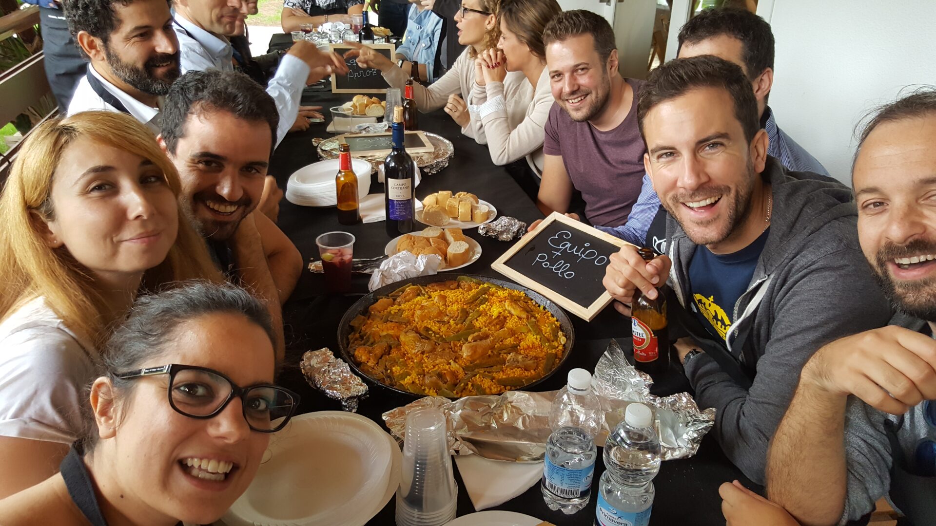 Compañeros de trabajo comiendo juntos la paella que han cocinado